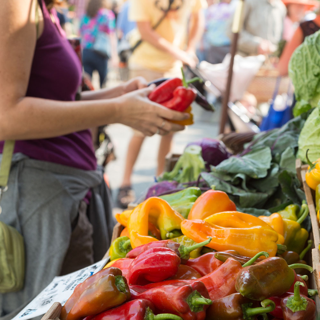 a woman inspects produce at her farmers market